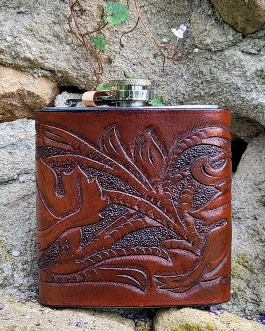 Edelstahl-Flachmann mit handgefertigtem Ledereinband, geziert von rankenden Weinblättern