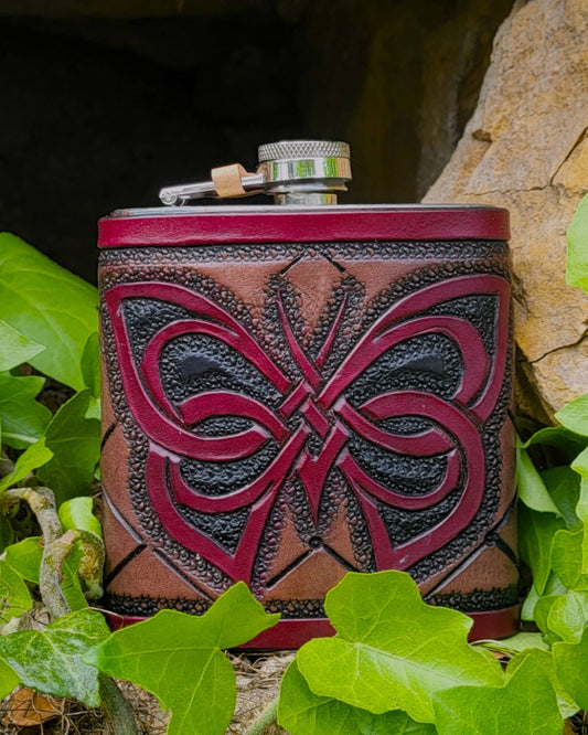 Edelstahl-Flachmann mit handgefertigtem Ledereinband, geziert von einem Schmetterling