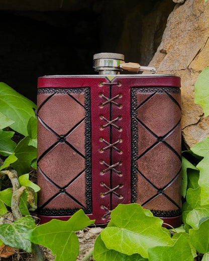 Edelstahl-Flachmann mit handgefertigtem Ledereinband, geziert von einem Schmetterling