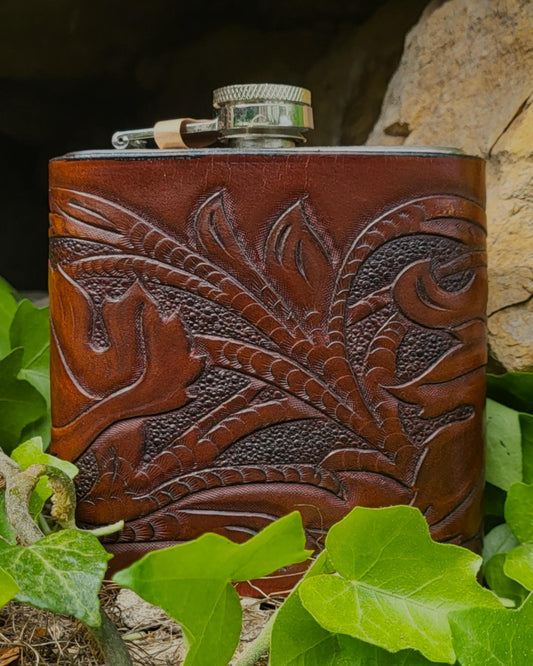 Edelstahl-Flachmann mit handgefertigtem Ledereinband, geziert von rankenden Weinblättern